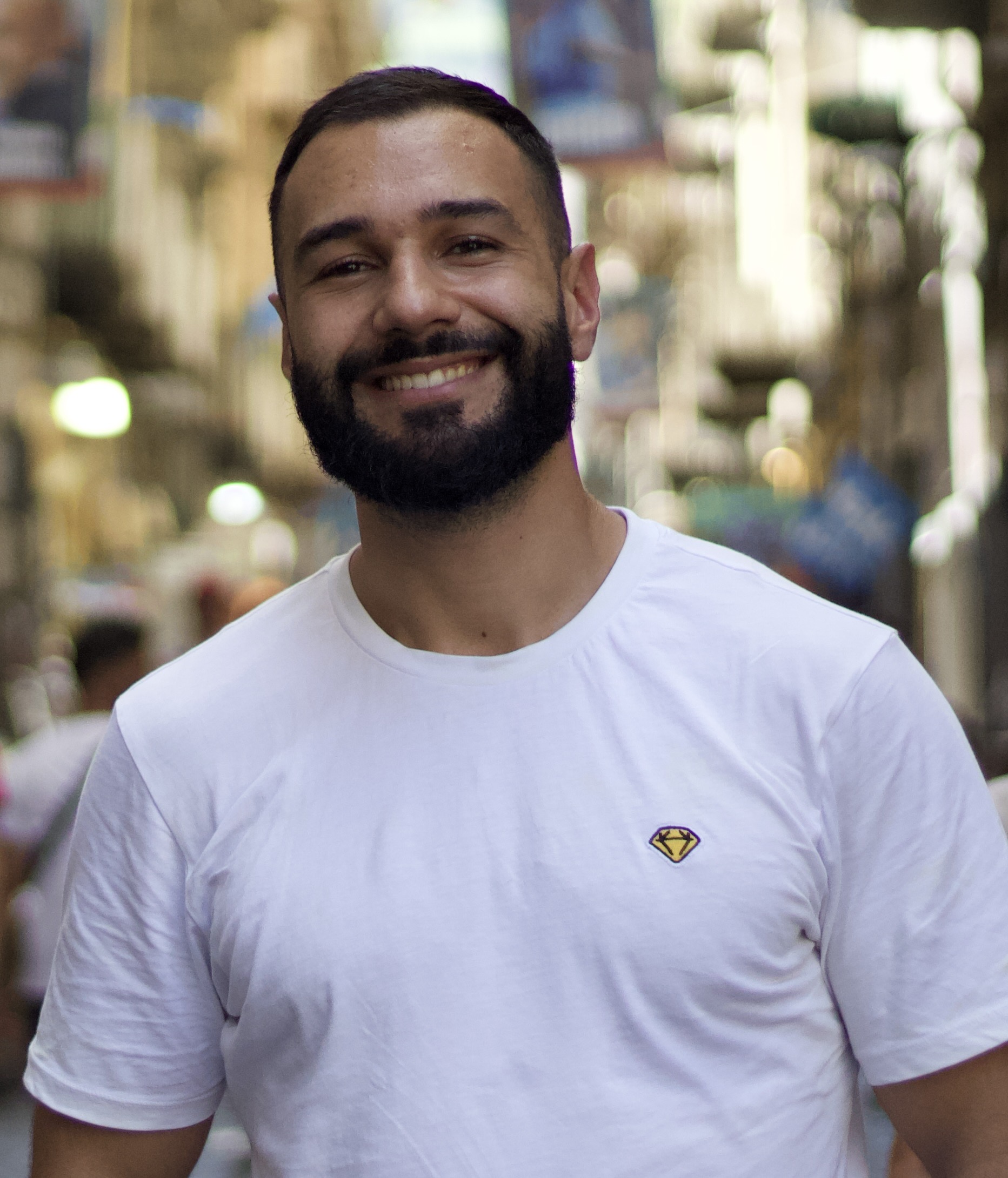 Daniel Pereira, de t-shirt branca, numa rua estreita